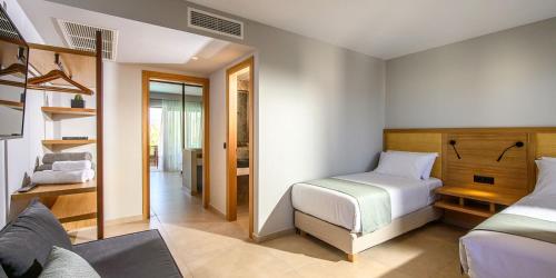 a bedroom with two beds and a room with a bathroom at Stella Palace Aqua Park Resort in Hersonissos