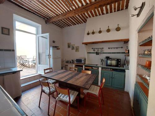 cocina grande con mesa de madera y sillas en Maison de César en Saint-Saturnin-dʼApt