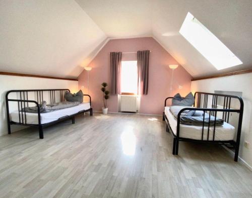 a attic room with two beds and a window at Ruhige-Ferienwohnung-auf-Pferdehof in Dreetz