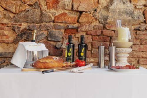 a table with bottles of wine and food on it at Masia Can Viver - Olive oil tourism B&B in Bigues i Riells
