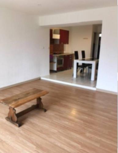 a living room with a wooden table and a kitchen at Appartement 50 m 2 à 15 min A 75 3 pers in Argelliers