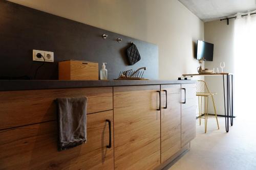 a kitchen with wooden cabinets and a television on a wall at Talbach Apartments in Buchen