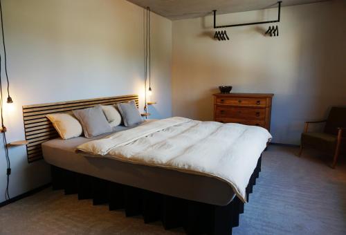 um quarto com uma cama grande e uma cadeira em Talbach Apartments em Buchen