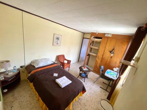 a bedroom with a bed and a desk and chair at Aruba Backpackers in Oranjestad