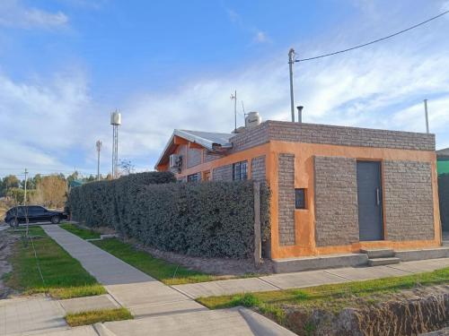 Un edificio de ladrillo con una valla delante. en Rayo Solar Depto Rama Caída, en San Rafael