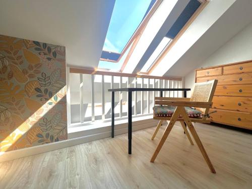 a attic room with a skylight and a table and a chair at Mandala Koszalin in Koszalin