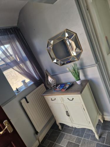 a mirror on top of a dresser with a window at Cierons château in Derry Londonderry