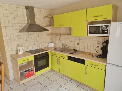 a kitchen with bright yellow cabinets and a sink at Au Pilandre in Arinthod