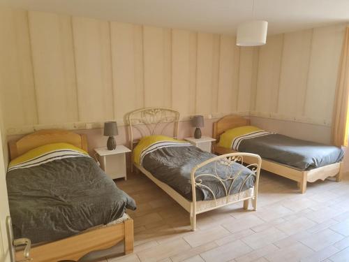 a room with two beds and two night stands at Au Pilandre in Arinthod