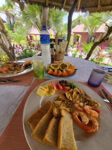 a table with a plate of food on a table at Asamai Villas in Sifoe