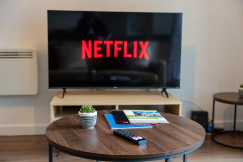 a living room with a table with a tv at Spacious Apartment in Woking Town Centre in Woking