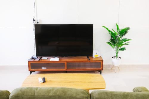 ein Wohnzimmer mit einem Flachbild-TV auf einem Tisch in der Unterkunft monstera homestay (Lenggong) in Kampong Ulu Jepai