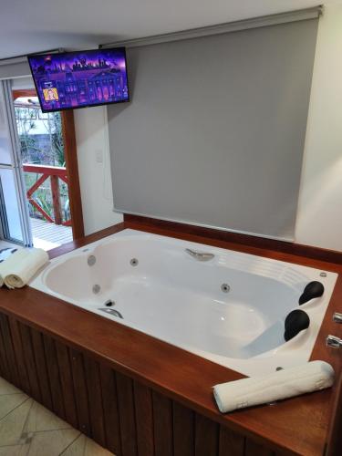 a large bath tub in a room with a window at Pousada la colline in Santo Antônio do Pinhal