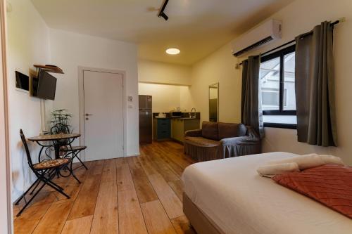 um quarto de hotel com uma cama e uma sala de estar em Zimmer Garden em Haifa