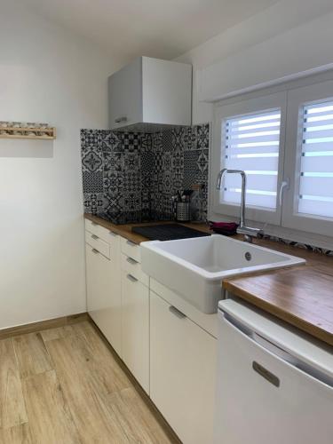 a kitchen with white cabinets and a white sink at Studio indépendant, front de mer et plage à 200m in Antibes