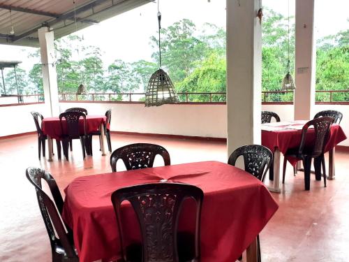 a room with tables and chairs with red table cloth at Subash Hotel in Nallathanniya