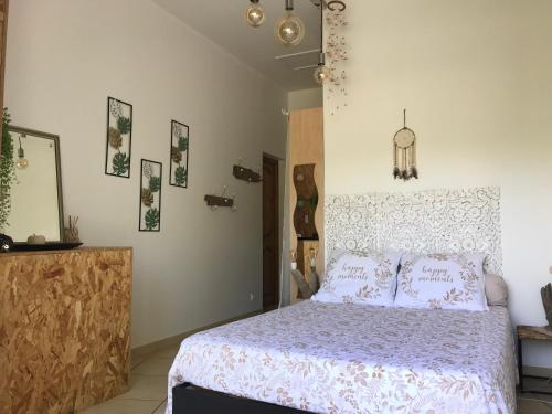 een slaapkamer met een bed met een paars dekbed bij LE CLOS DES VIGNES in Junas