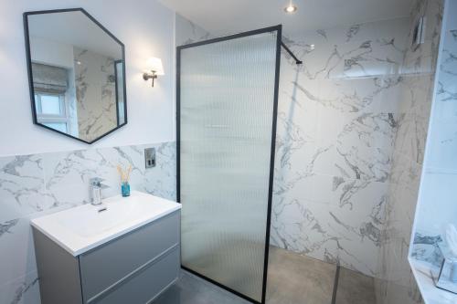 a bathroom with a shower and a sink and a mirror at Rowton Hall Hotel and Spa in Chester