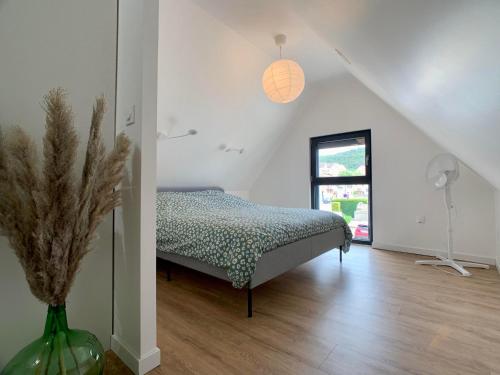 1 dormitorio con 1 cama y un jarrón con una planta en Chez Arnaud et Thomas, en Dinsheim