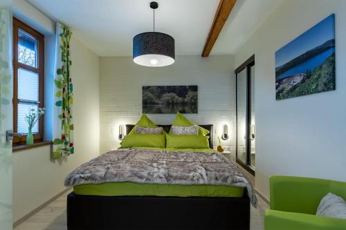 een slaapkamer met een groot bed met groene kussens bij Ferienwohnung-Meiser in Oberwaroldern