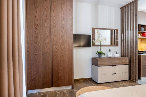 a bedroom with a large wooden closet and a television at Anna Suites in Kos Town