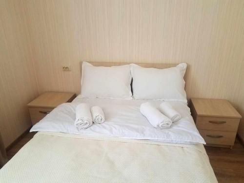 a white bed with two pillows and two tables at M7 House in Gorists'ikhe