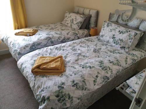 a bedroom with two beds with towels on them at large comfortable 1st floor apartment with private yard in Longtown