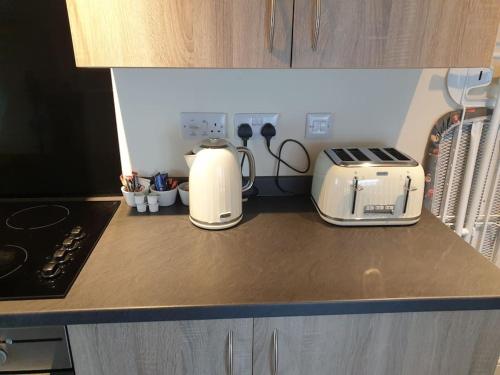 a kitchen counter with two toasters and a toaster at large comfortable 1st floor apartment with private yard in Longtown