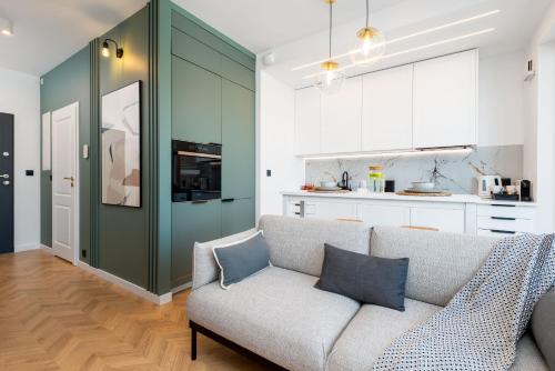 un soggiorno con divano e cucina di Kairos Apartments - Tower Premium - parking, siłownia, sauna, ścisłe centrum a Katowice