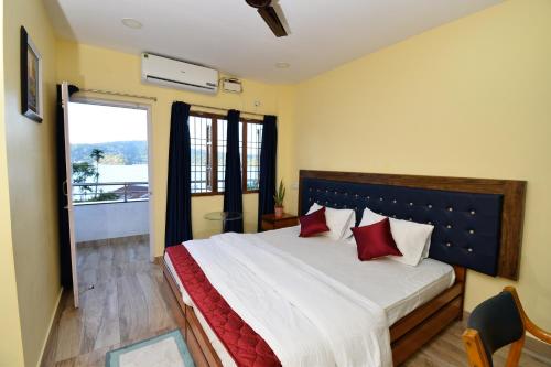 ein Schlafzimmer mit einem großen Bett mit roten Kissen in der Unterkunft The Hook BnB, Port Blair in Haddo