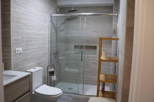 y baño con ducha, aseo y lavamanos. en Palm Beach Apartment in La Duquesa en Manilva
