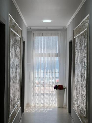 a room with a large window with a vase of flowers at Гостевой дом Razamlux in Bosteri