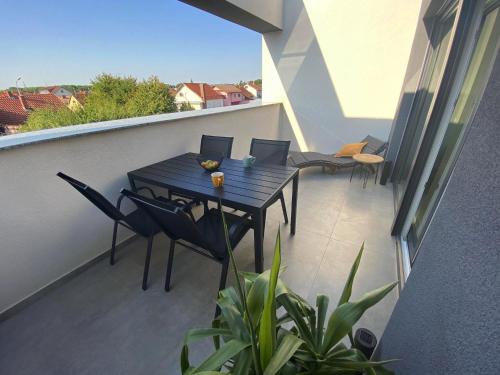 a balcony with a table and chairs on a balcony at 2 Terraces Apartment in Urban Villa - MLII in Varaždin