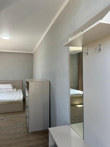 a white room with a mirror and a bed at Гостевой дом Razamlux in Bosteri
