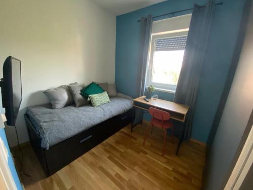 Habitación pequeña con cama, escritorio y ventana. en 2 Terraces Apartment in Urban Villa - MLII, en Varaždin
