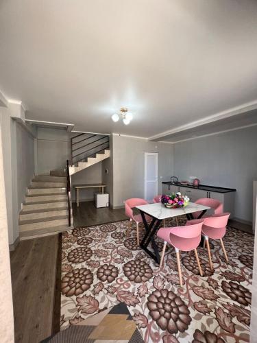 a living room with a table and pink chairs at Гостевой дом Razamlux in Bosteri