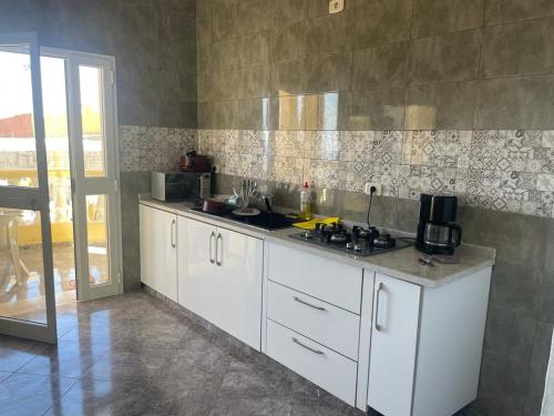 cocina con armarios blancos y encimera en Villa Belle-Vue, en Tabarka