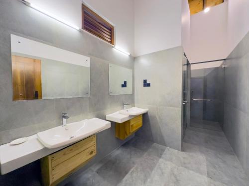 uma casa de banho com 2 lavatórios e um chuveiro em Tropical Villa - Weligama em Weligama
