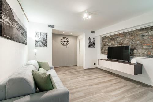 a living room with a couch and a flat screen tv at Olimpia Via Vitani - The House Of Travelers in Como