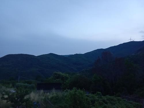 a view of a mountain with a windmill on top at LA TANA DELLA VOLPETTA - Bed & Breakfast in Stella