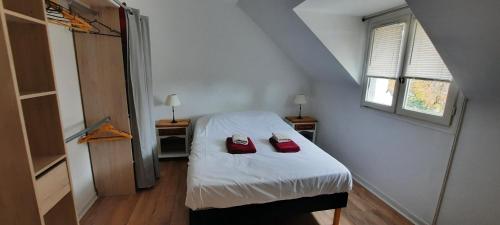 een slaapkamer met een bed met rode schoenen erop bij Maison typique bretonne in Vannes