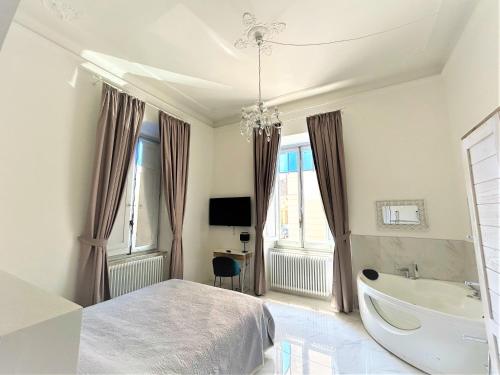 a bedroom with a bed and a tub and a sink at Allegra Viareggio Appartamento & Affittacamere Guest house in Viareggio