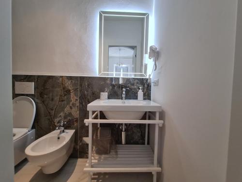 a bathroom with a sink and a toilet and a mirror at Allegra Viareggio Appartamento & Affittacamere Guest house in Viareggio