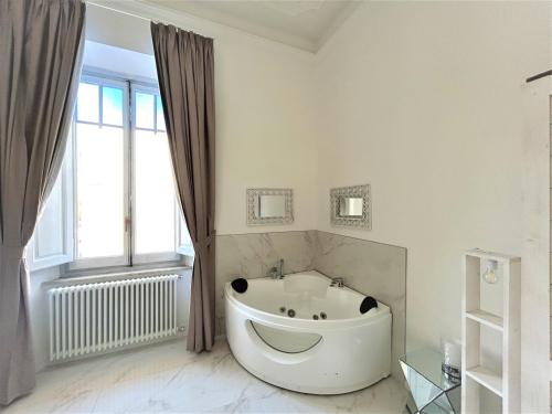 a large white bath tub in a bathroom with a window at Allegra Viareggio Appartamento & Affittacamere Guest house in Viareggio
