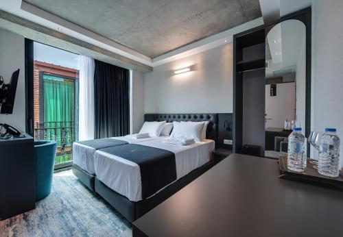 a bedroom with a large bed and a large window at Mit Hotel Tbilisi in Tbilisi City