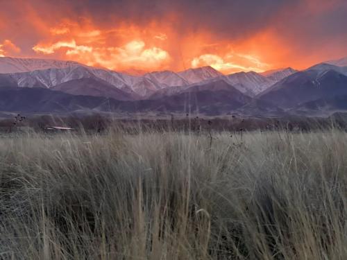 a sunset over a field with mountains in the background at Rancho Adobe Eco Hotel in Tupungato