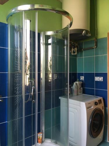 a bathroom with a shower and a washing machine at Double storey loft in family vila near Prague city center in Prague