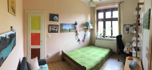 a bedroom with a green bed and a window at Double storey loft in family vila near Prague city center in Prague