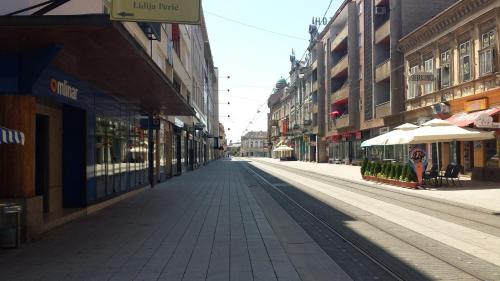an empty street in a city with buildings at Apartment Travego II in Osijek