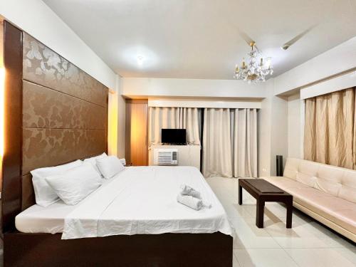 a bedroom with a large bed and a couch at Luxury Hotel Type Condo Near NAIA Manila Airport in Manila